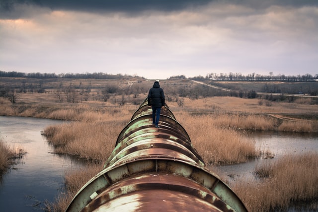 Man standing on an oil pipeline
